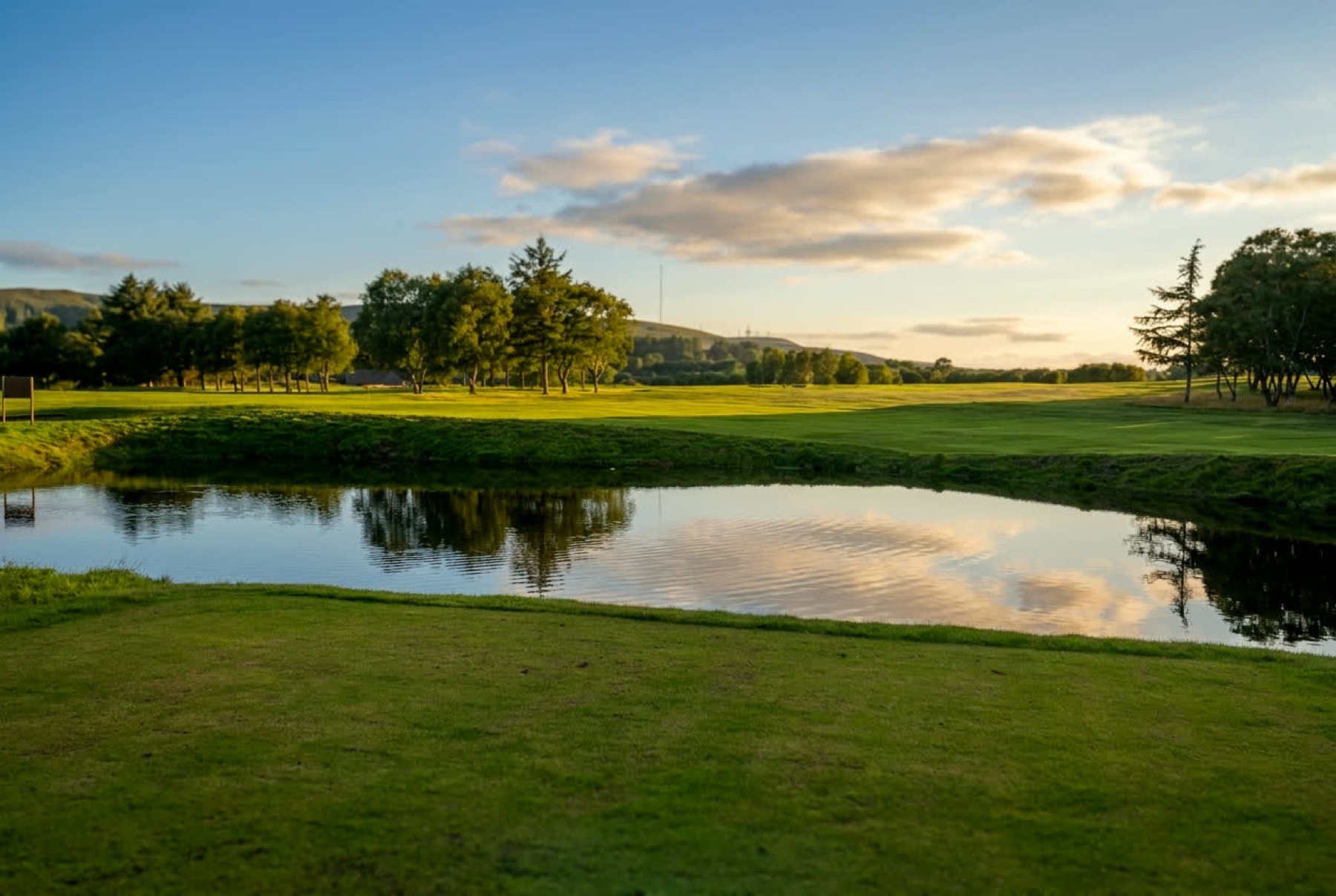 Water guarding the 3rd hole, 'Watermans', at Dunscar Golf Club at golden hour